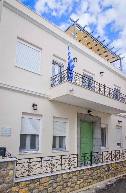 a white house with a green door at Villa St George in Kalymnos
