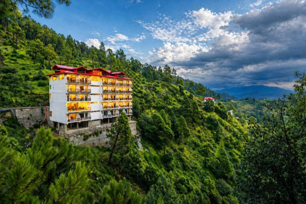 a building on the side of a hill with trees at Kavin - The Chail Resort in Chail