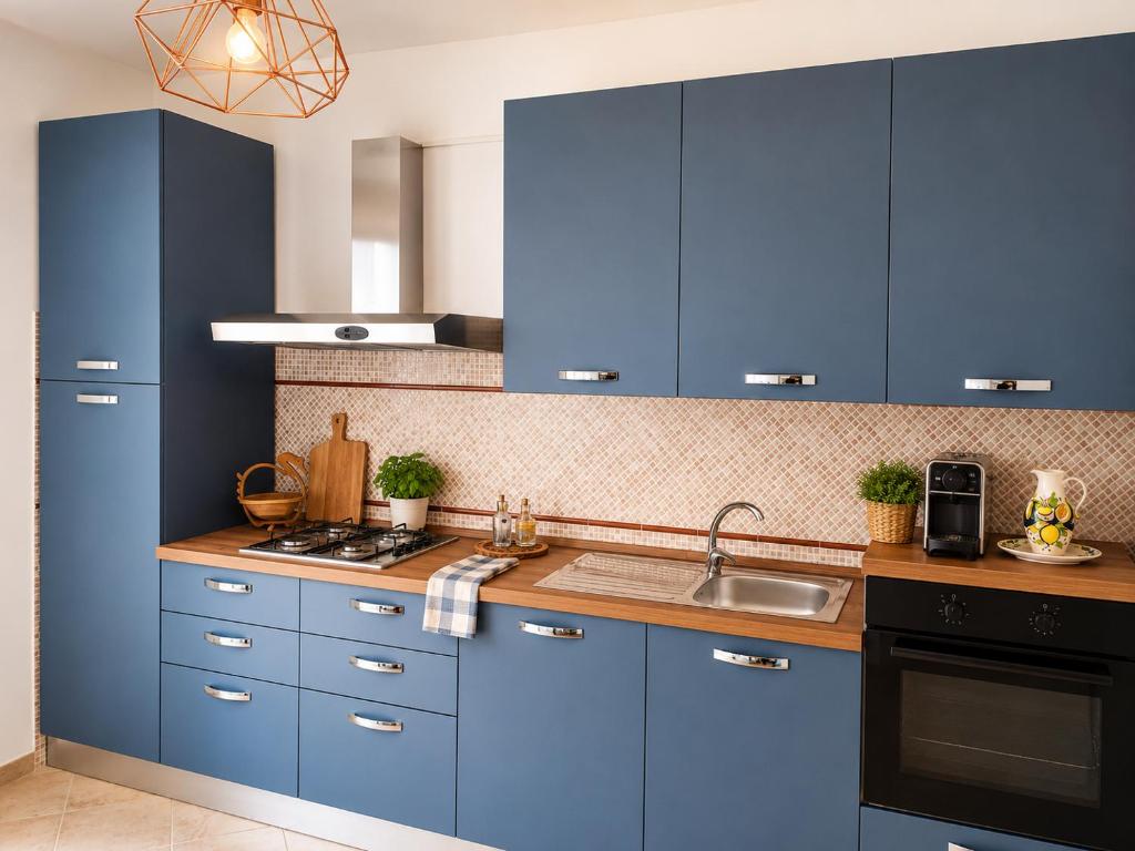 a kitchen with blue cabinets and a sink at Optima Casa Vacanze II in Telese
