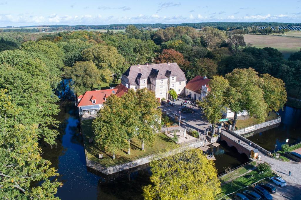 an aerial view of a house on an island in a river at Hotel Wasserschloss Mellenthin in Mellenthin