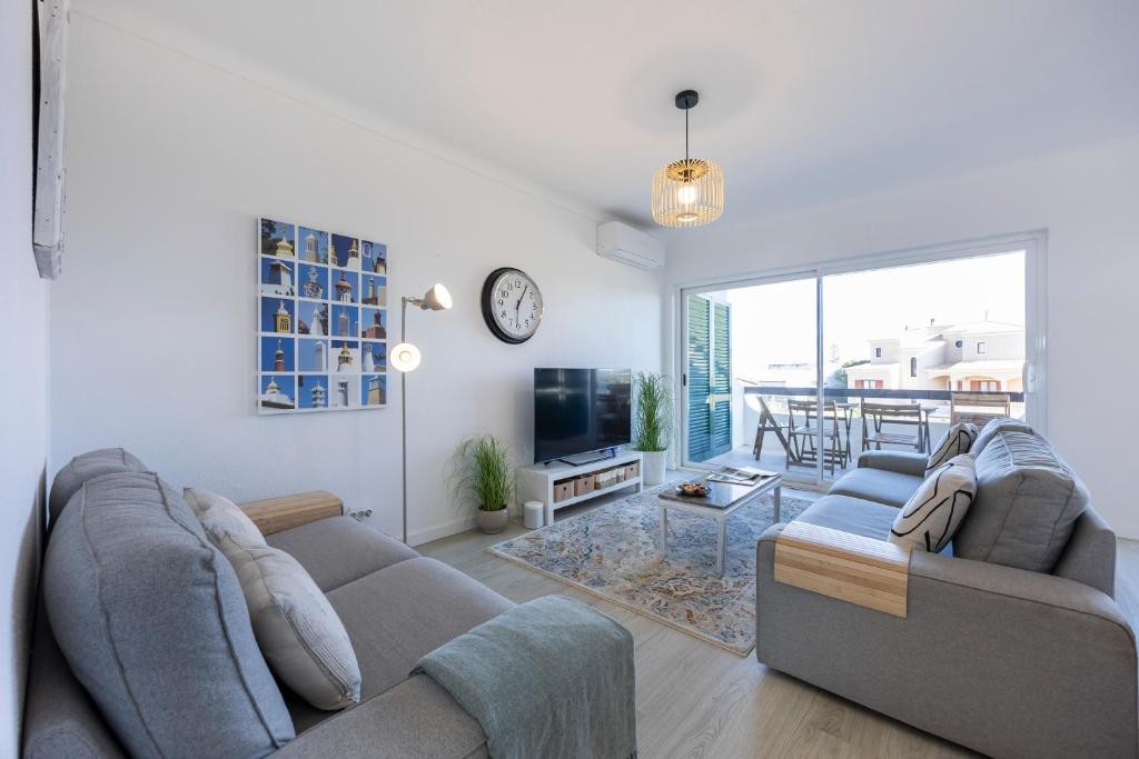 a living room with a couch and a tv at Apartment Julio Pomar, swimming pool in Sagres