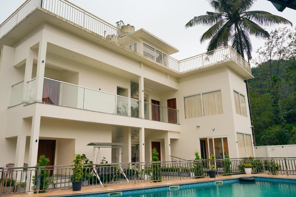 a building with a swimming pool in front of it at La Dimora luxury pool villa in Vythiri