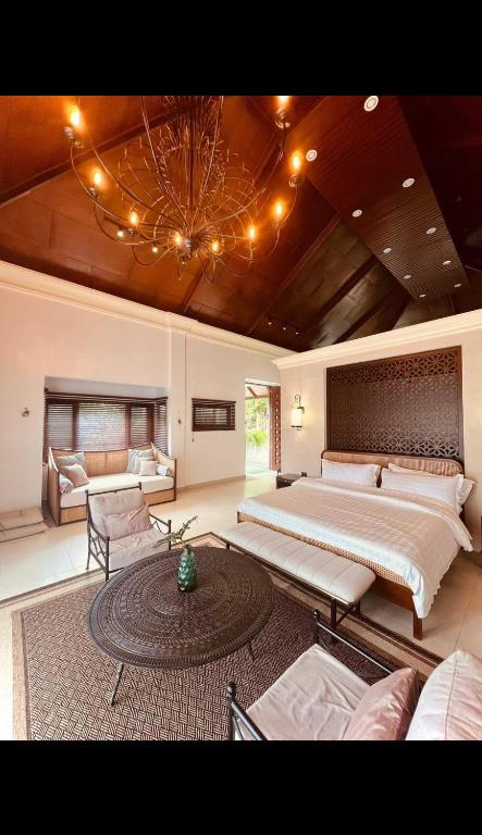 a large bedroom with two beds and a chandelier at The Villa at Mertolas in Alitagtag