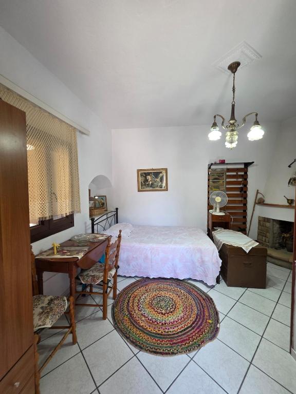 a bedroom with a bed and a table and a desk at Sidirounta Traditional Home 2 in Chios