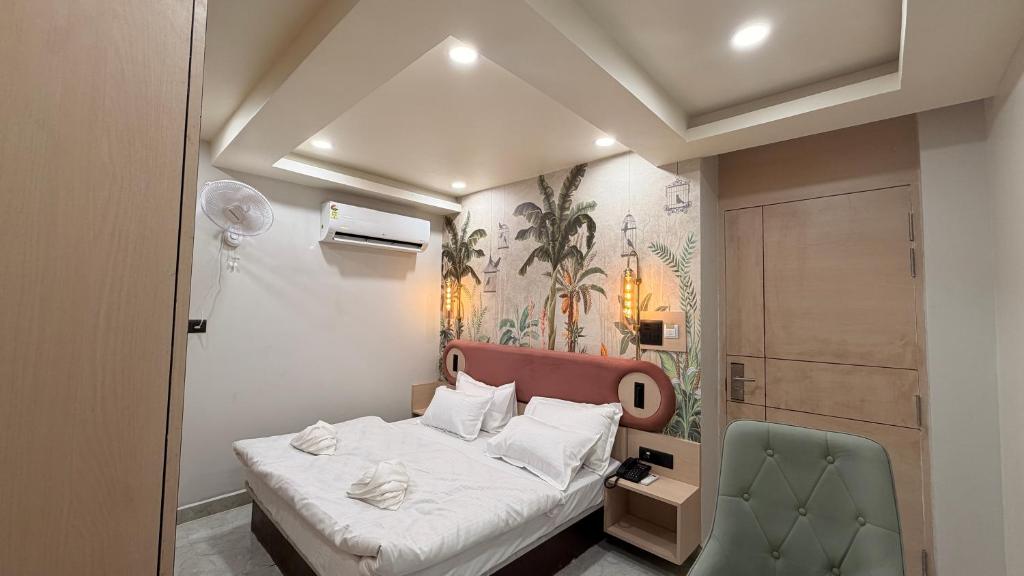 a small bedroom with a bed and a green chair at Shridhar inn in Alīganj