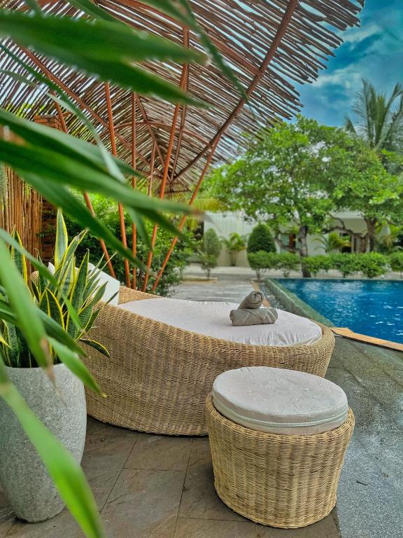a resort with a pool and wicker chairs and a table at Home Escape Resort in Kaôh Rŭng (3)