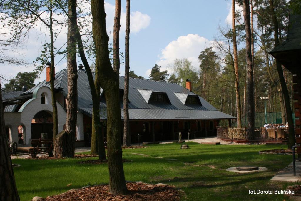 a large building with a gambrel roof on a green yard at Nostalgia in Sokolniki