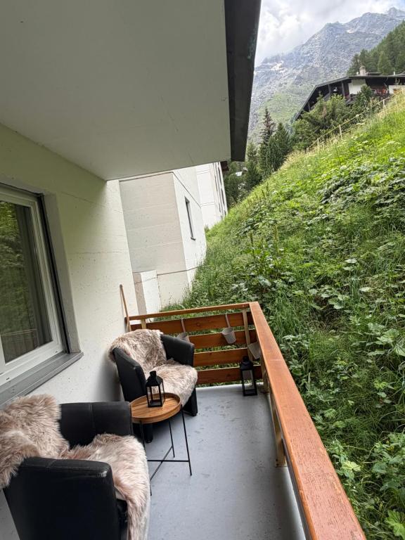 a balcony with two chairs and a table on a hill at Apollo in Saas-Fee