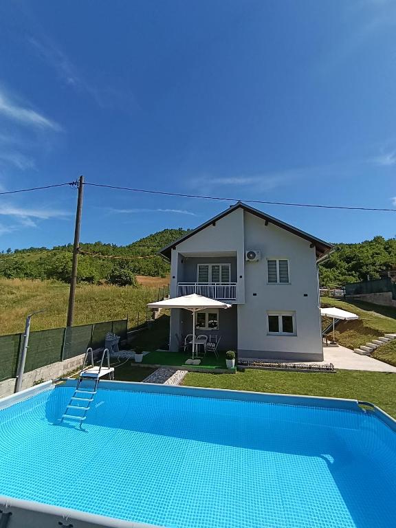 a house with a swimming pool in front of a house at Vikend kuća Konjic in Konjic