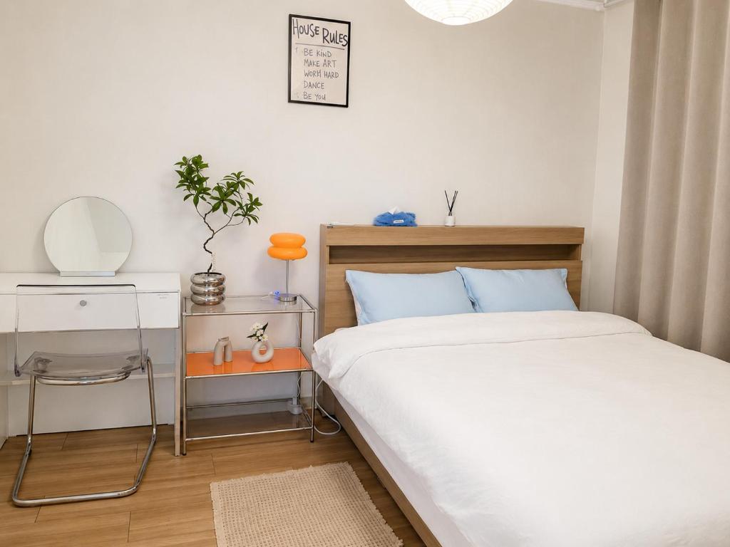 a bedroom with a bed and a table and a mirror at Herry Stay in Seoul
