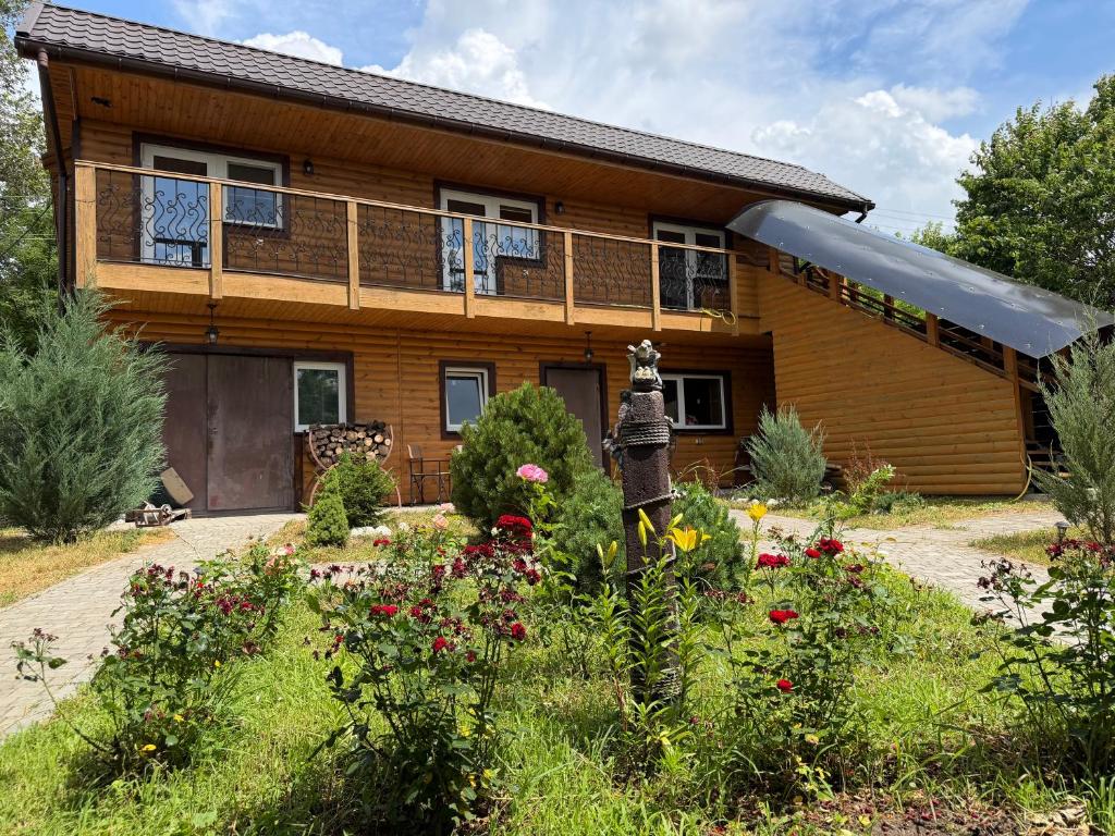 a house with a garden in front of it at Міні-готель На Росі in Steblëv