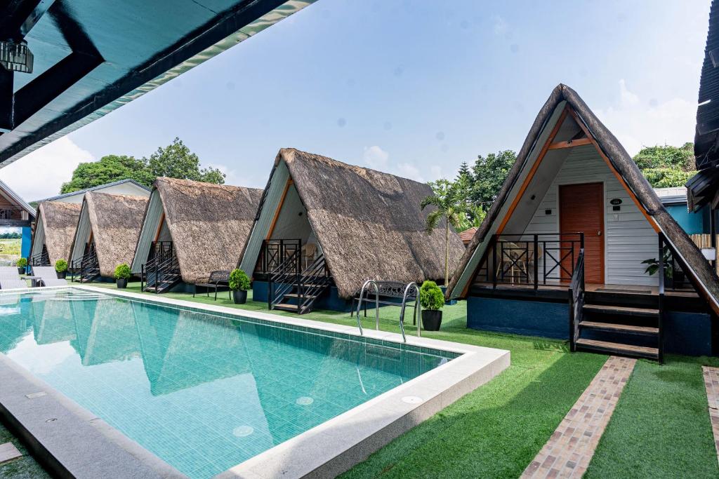 a row of cottages with a swimming pool at Paragos Silvina's Cabin 2 Resort Hotel in Maitim