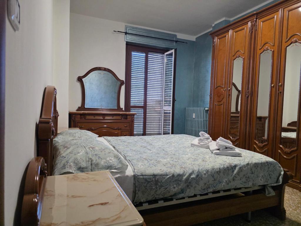 a bedroom with a bed and a dresser and a table at Da Silvia ampio appartamento metro Paradiso in Collegno