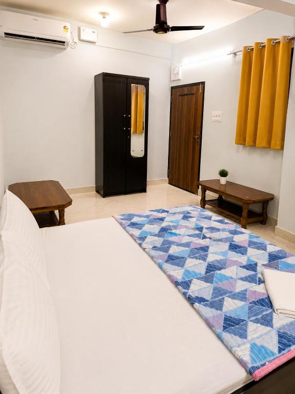 a bedroom with a bed and a blue and white rug at Shri Shyam Kunj Hotel in Ambikāpur