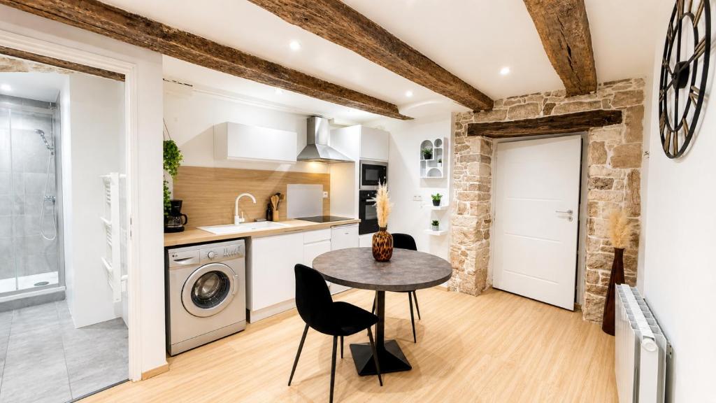 a kitchen with a table and a washing machine at L'Adresse Mâconnaise Central - 2pers - Calme in Mâcon