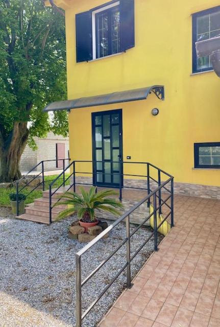 a yellow house with a staircase and a door at Agriturismo Terra Del Mare in Fossalòn