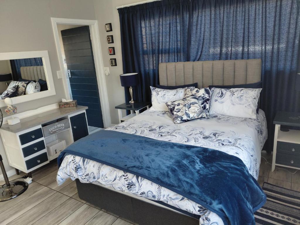 a bedroom with a bed with a blue comforter at Naomi's Sky Loft Little Falls in Roodepoort