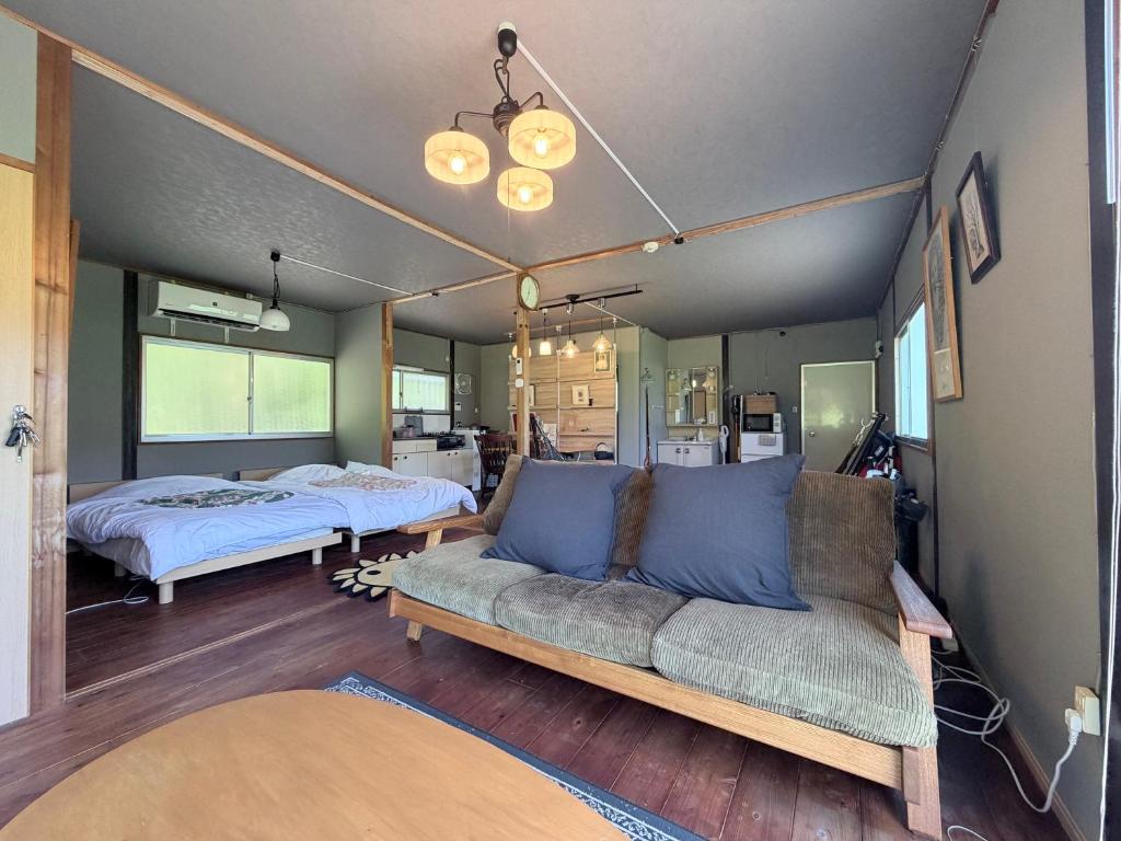a living room with a couch and two beds at KUMANOYASAI BASE in Chikatsuyu in Chikatsuyu