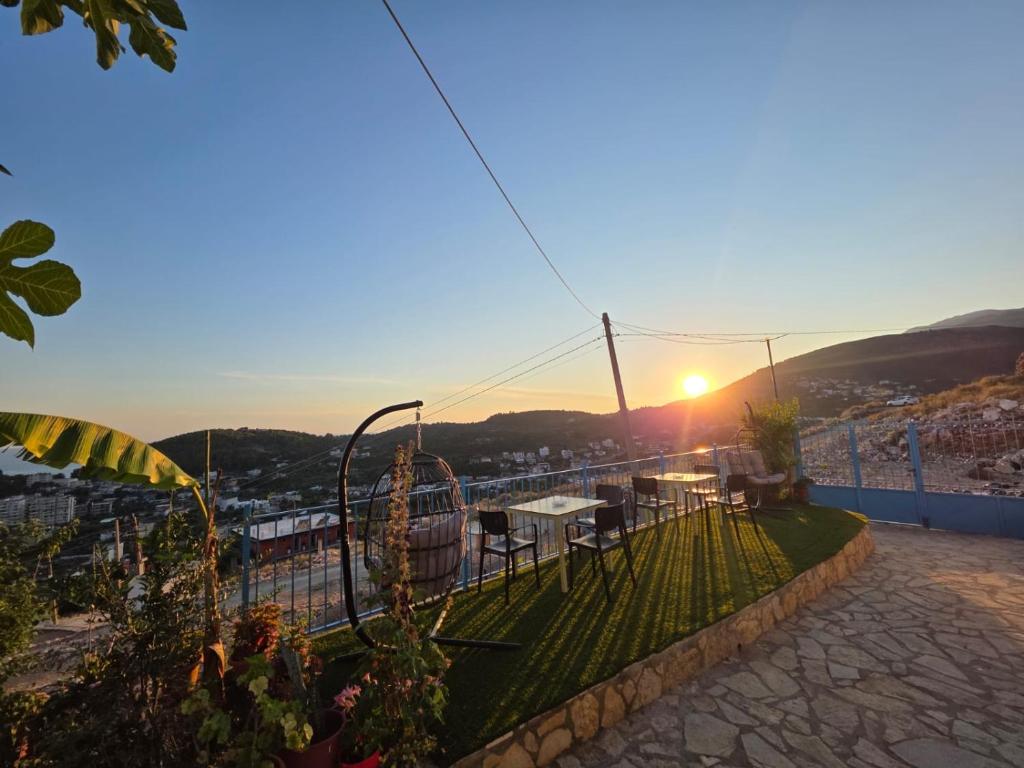 a table and chairs on a balcony with the sunset at Zoi's sea view in Himare