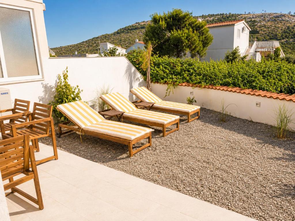 a group of chairs sitting on a patio at Lady A Apartment Jacuzzi Garden Outdoor Kitchen in Podglavica
