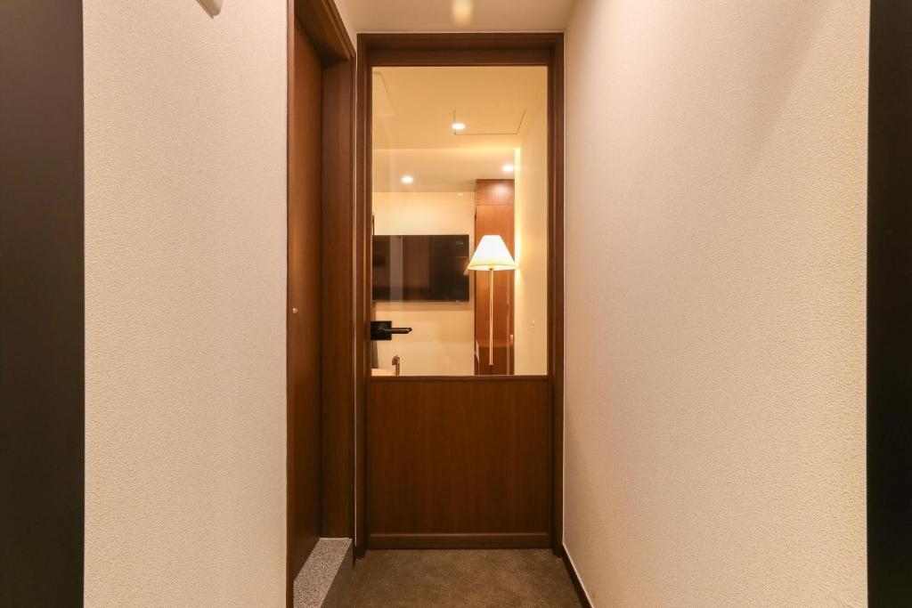 a hallway with a door leading into a room at LUVO Signature Hotel in Seoul