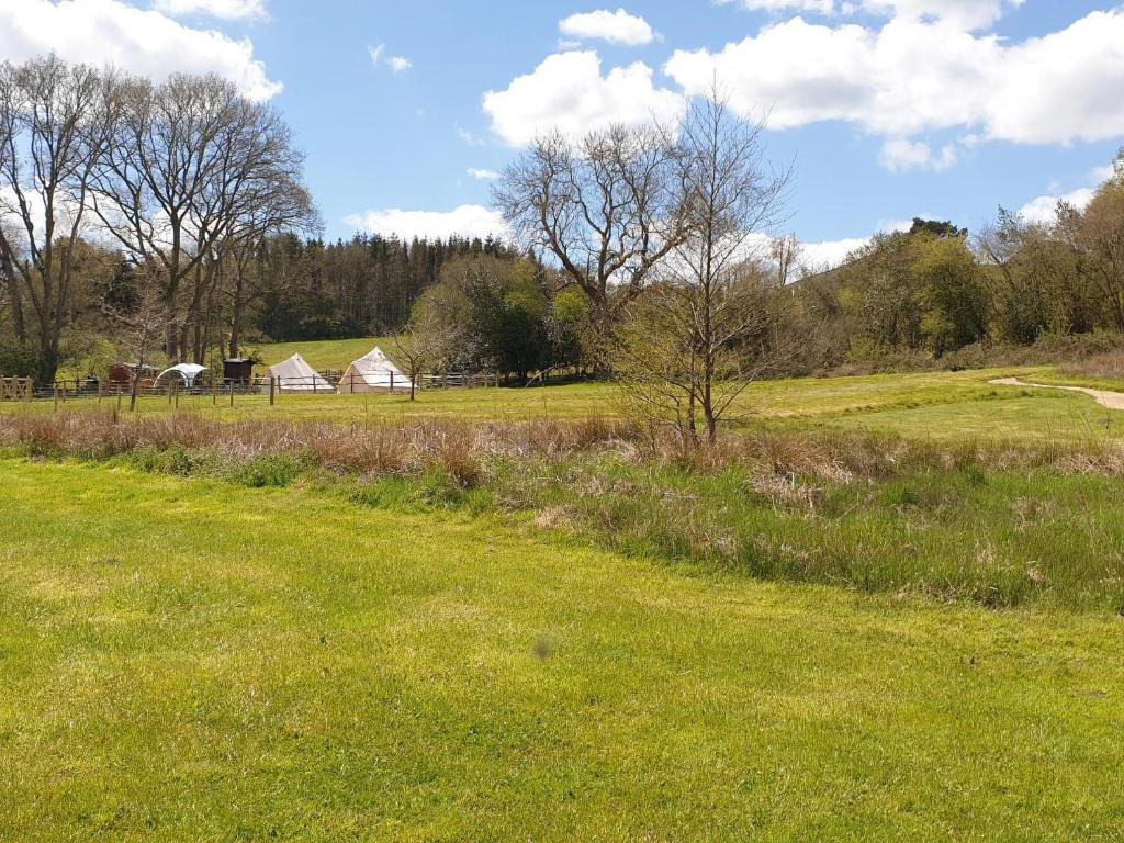 a field of green grass with a barn in the background at Ash Cottage in Uckfield