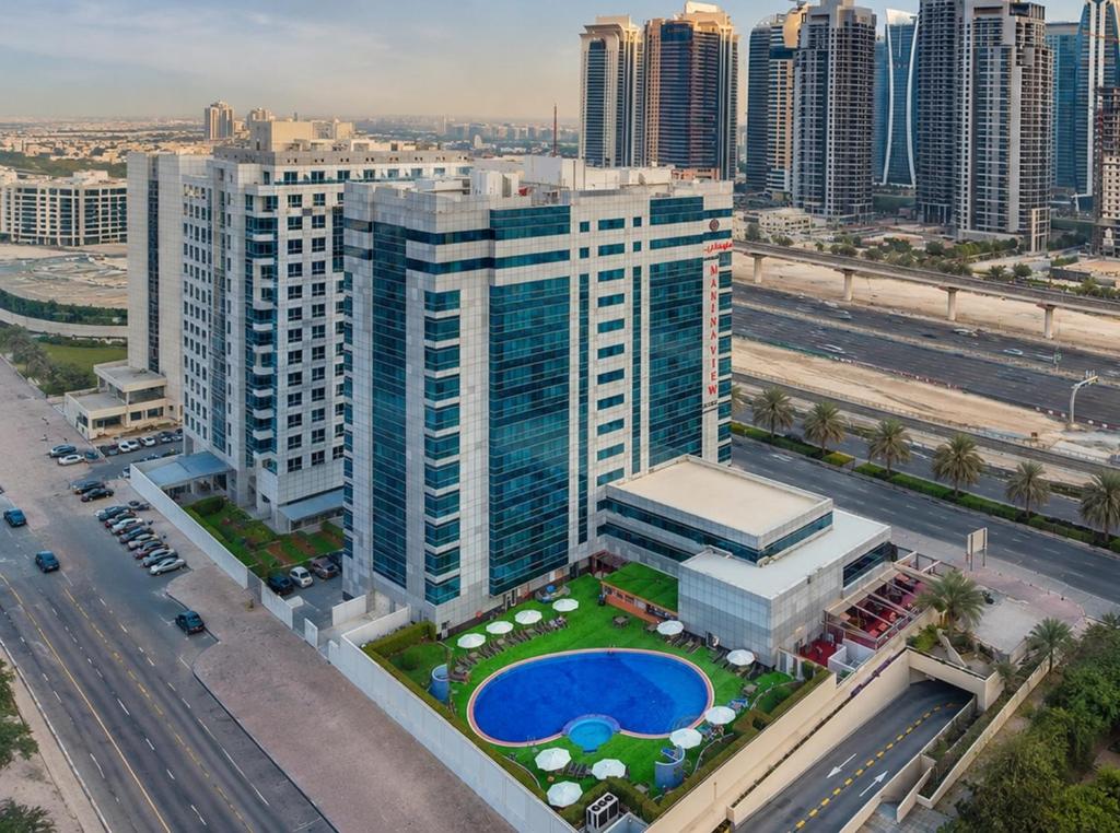 an aerial view of a tall building with a pool at Sunday Marina View Hotel Apartments in Dubai