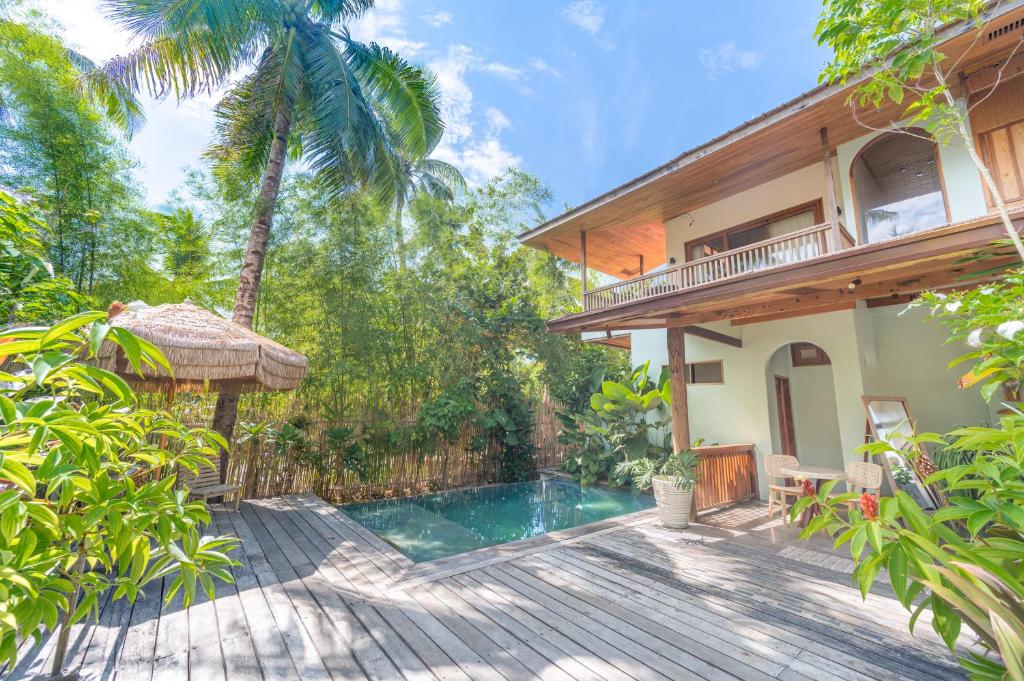 a house with a wooden deck and a swimming pool at Camanolo Residence in General Luna