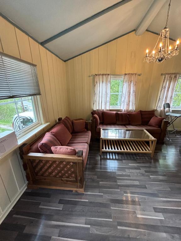 a living room with couches and a chandelier at Detached cozy house in Lom