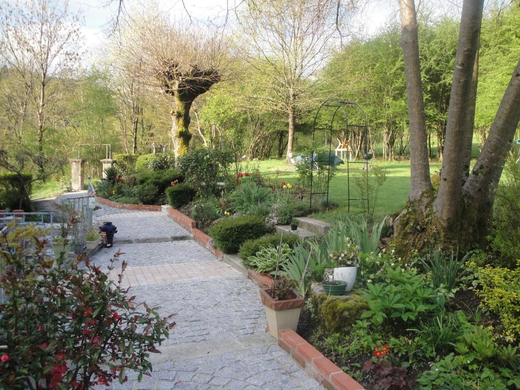 einen Garten mit Pflanzen und einem Pfad in einem Park in der Unterkunft Le Relais des Capucines in Largnac
