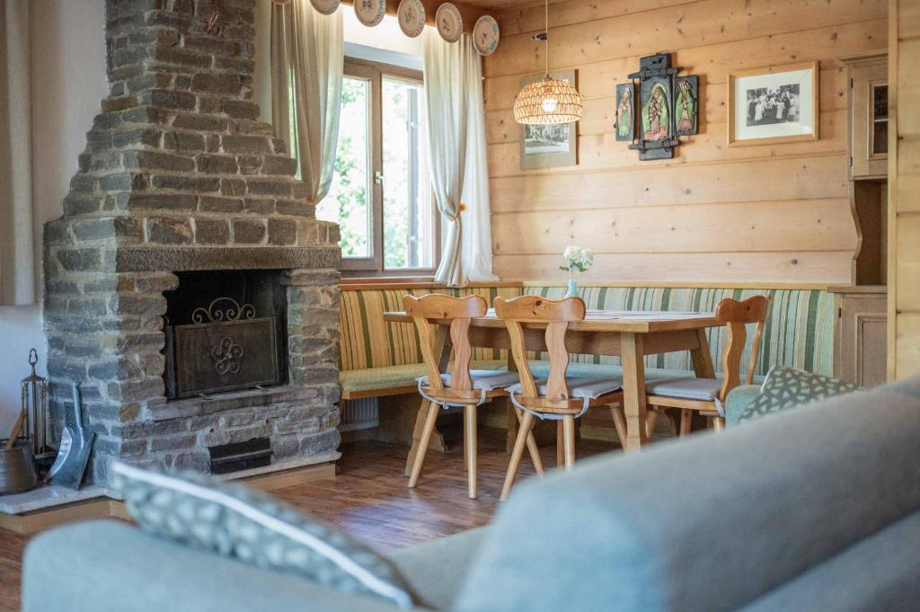 a dining room with a fireplace and a table and chairs at Alpen Suite Apartment in San Vigilio Di Marebbe