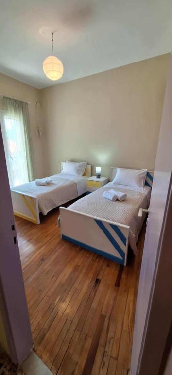 zwei Betten in einem Zimmer mit Holzboden in der Unterkunft levanta in Konitsa