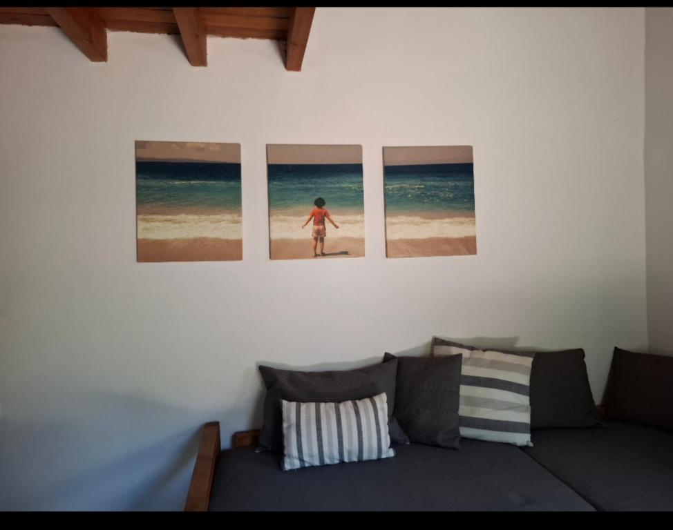 a living room with three pictures of a girl on the beach at La casa di Kapo in Syvota