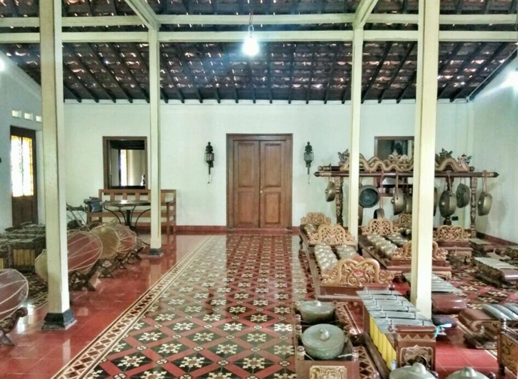 a room filled with lots of furniture and a wooden door at Omah Pitoe Yogya Homestay in Yogyakarta