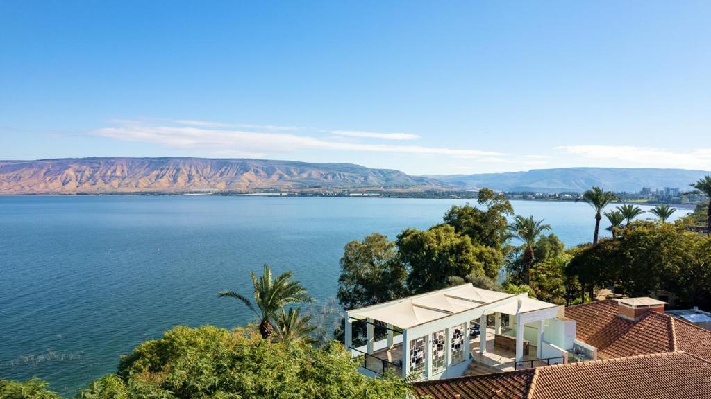 a house on the shore of a large body of water at Jacob Ohalo Kinneret in Kinneret