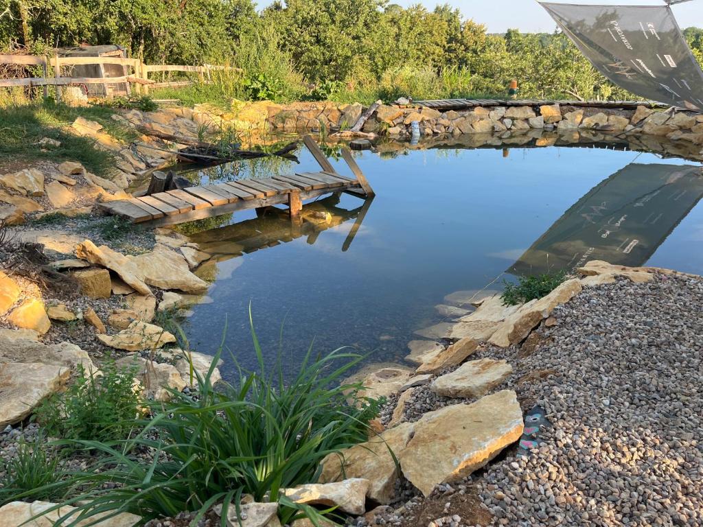 a pool of water with a bridge over it at Le petit Permadise in Chassiecq