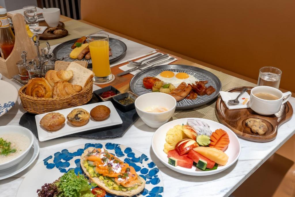 A generously arranged breakfast spread with hot dishes, pastries, fruit, juice and coffee.