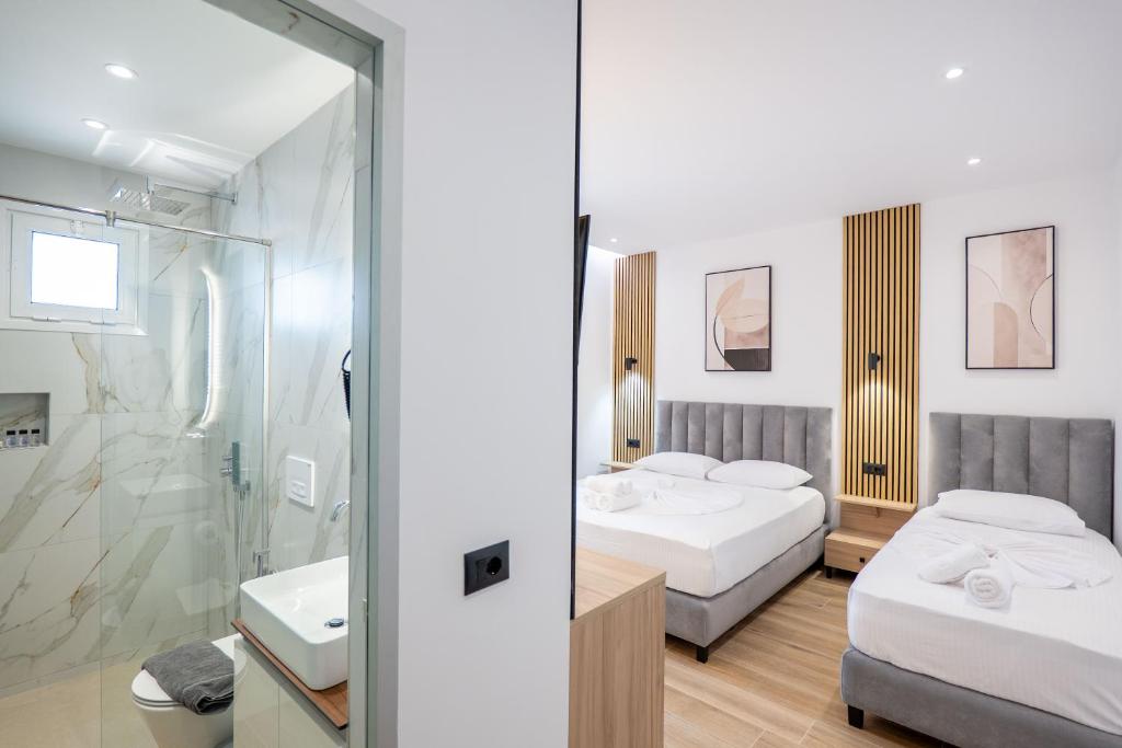 a hotel room with two beds and a shower at Ionian View Rooms in Himare
