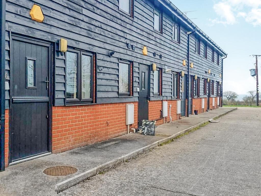 a blue building with a row of windows on a street at Mistletoe No3 -Uk49252 in Althorne