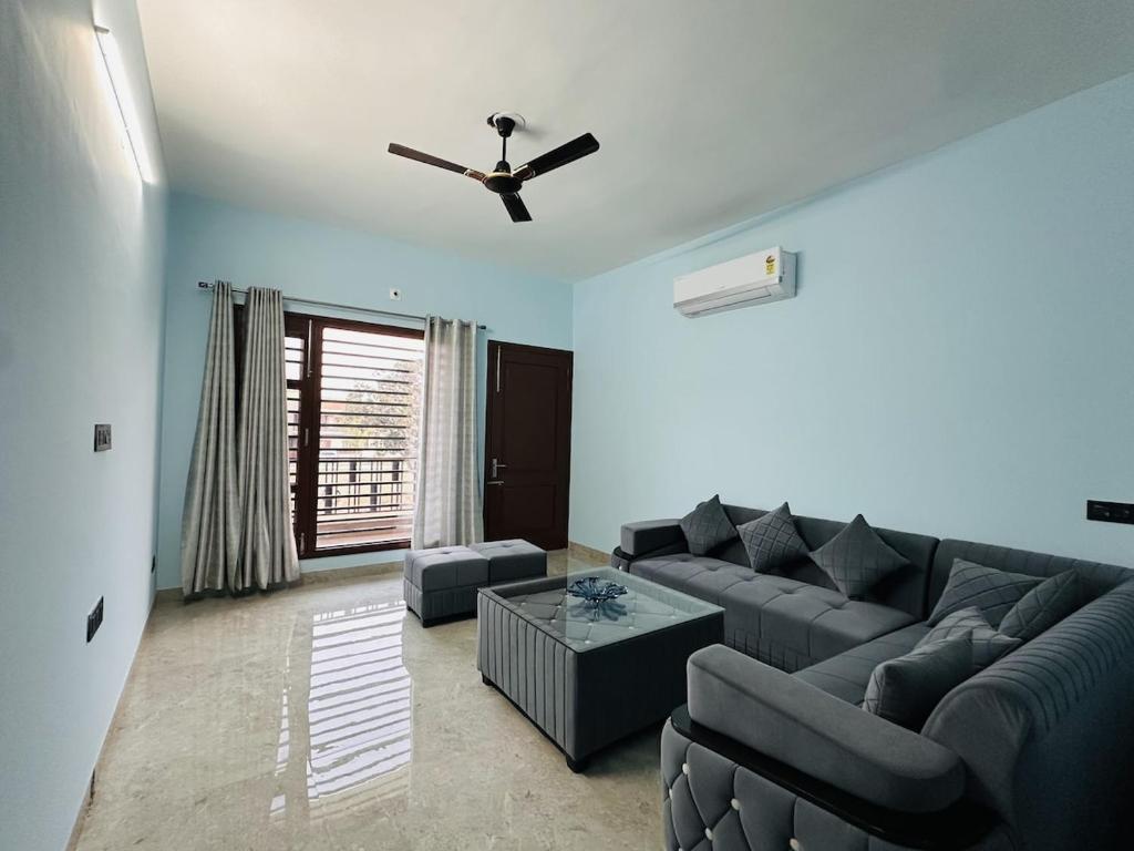 a living room with a couch and a ceiling fan at Comfy Corner in Chandīgarh
