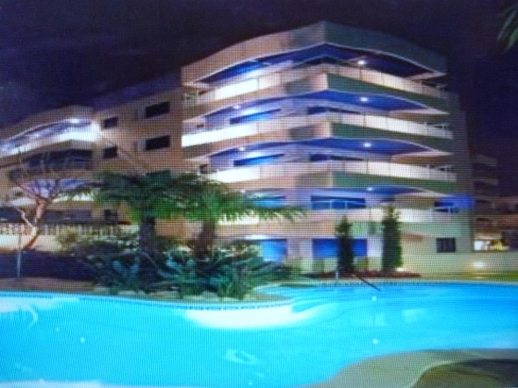 un edificio con piscina frente a un edificio en Apartamento Ones Playa Mero, en Salou