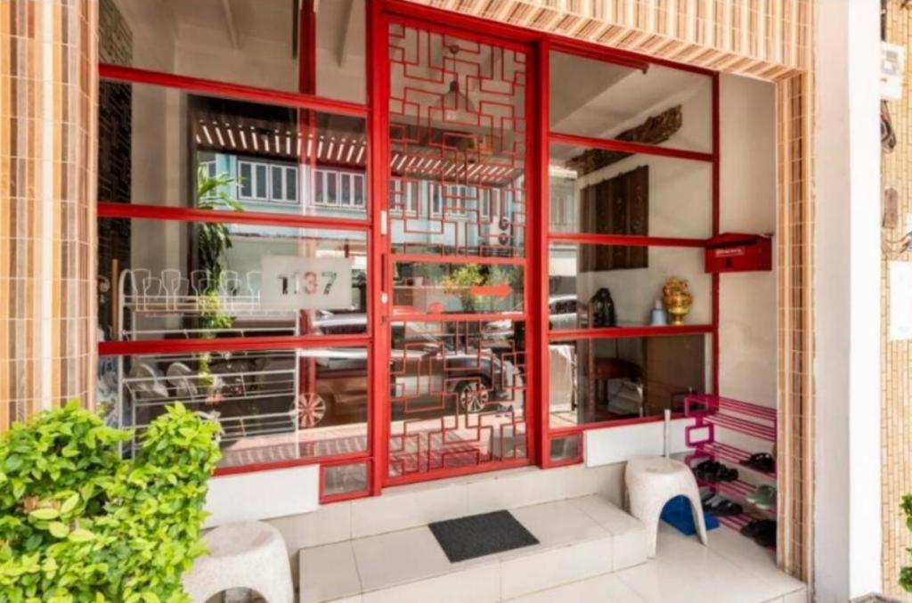a window of a store with a red frame at 1137 Hostel in Bangkok