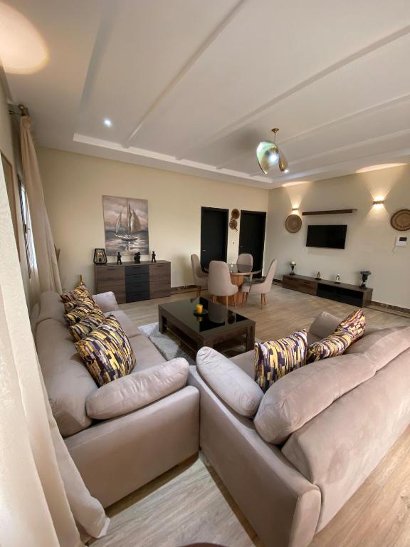 a living room with two couches and a flat screen tv at Villa La Gospa in Libreville