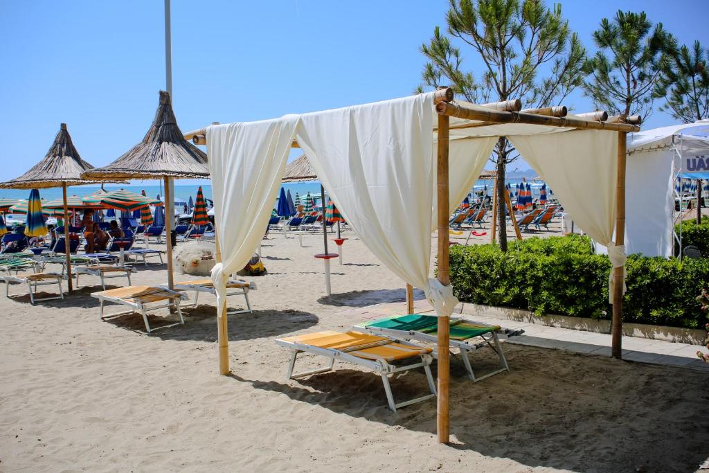 Apartments Bella Vista في دوريس: مظلة على الشاطئ مع الكراسي والمظلات