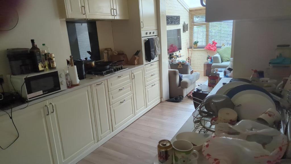 a kitchen with white cabinets and a bunch of toys at Rashas double room in London
