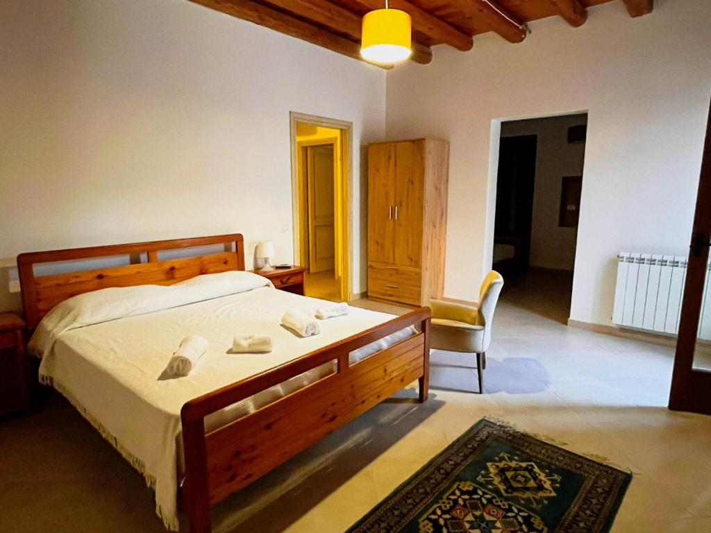 a bedroom with a large bed and a chair at Casa Vacanza Acquanuova in Calatafimi