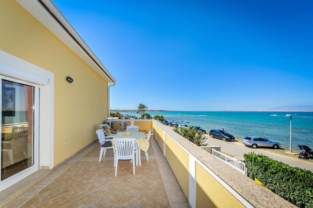 a balcony with a table and chairs and the ocean at Apartments Dominique in Nin
