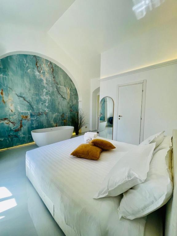 a white bedroom with a large bed and a bath tub at Zagara Suite in Francofonte
