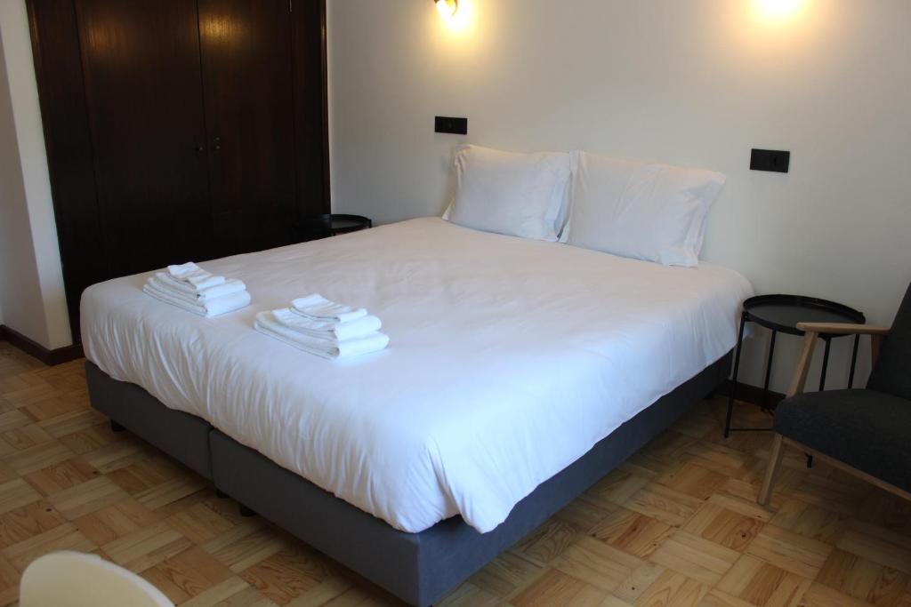 a bedroom with a bed with towels on it at Lavanda Termas de São Pedro do Sul in Termas de Sao Pedro do Sul