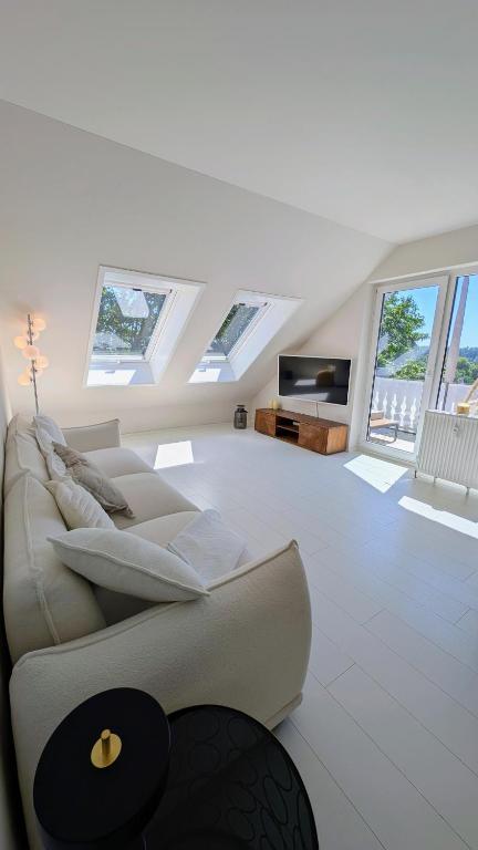 a white living room with a couch and windows at FREISTIEL 4 in Hattenheim